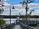 Wooden dock leading to a gazebo on a tranquil lake with lush green surroundings at 3468 Soho St # 107, Orlando, FL 32835