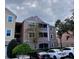 Three-story exterior view of condo with screened lanai at 3468 Soho St # 107, Orlando, FL 32835