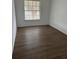 Bright bedroom with large window and wood-look flooring at 6008 Village Cir # Ge, Orlando, FL 32822