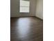 Bright bedroom with large window and wood-look floors at 6008 Village Cir # Ge, Orlando, FL 32822