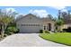 Tan one-story house with a paved driveway and landscaped yard at 120 Vizcaya Ct, Poinciana, FL 34759