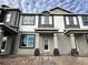 Two-story townhome with gray and white siding, front porch, and brick walkway at 1380 Lumpini St, Saint Cloud, FL 34771