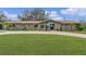 A single-story home with a brick driveway, green lawn, and symmetrical landscaping at 1407 Edgewater Beach Dr, Lakeland, FL 33805