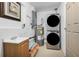Functional laundry room with stacked washer and dryer and a sink, all in a utility space at 1407 Edgewater Beach Dr, Lakeland, FL 33805