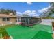 A partially covered backyard patio featuring a white bench and lush green turf for relaxing and entertaining at 1407 Edgewater Beach Dr, Lakeland, FL 33805
