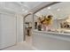 Hallway featuring white tile floors and an arched entryway into a dining area with a chandelier at 642 Wheeling Ave, Altamonte Springs, FL 32714