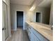 Bathroom showcasing double sinks, quartz countertops, a large mirror, and access to walk-in closet at 1344 Lumpini St, Saint Cloud, FL 34771