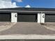 New townhomes featuring multiple garages with paved brick driveways and black accents at 1344 Lumpini St, Saint Cloud, FL 34771