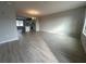 Open-concept living room with modern gray flooring leading to the kitchen area at 1344 Lumpini St, Saint Cloud, FL 34771