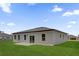 Back exterior of home with sliding glass doors, modern windows, and a green backyard at 15123 Sw 61St Court Rd, Ocala, FL 34473