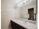 Bathroom featuring a large mirror with a single sink and dark cabinets at 2142 Brandywine Falls Way, Orlando, FL 32824