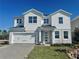 Striking two-story home featuring a clean white facade, a two-car garage, and well-manicured landscaping at 1165 Basalt Ln, Sanford, FL 32771