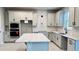 Bright kitchen featuring white cabinets, stainless steel appliances, and a large island with a quartz countertop at 1165 Basalt Ln, Sanford, FL 32771