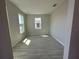 An empty, bright room with beautiful wood-look floors and lots of natural light at 1360 Lumpini St, St Cloud, FL 34771