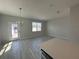 Open-concept living room with a view of the patio, featuring a modern chandelier at 1360 Lumpini St, St Cloud, FL 34771
