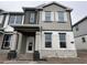 Two-story home showcasing a blend of stone and siding accents, complemented by contrasting black and white trim at 1364 Lumpini St, St Cloud, FL 34771