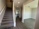 Bright foyer with staircase and views of open-concept living spaces featuring hard surface floors at 1364 Lumpini St, St Cloud, FL 34771