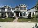 Charming two-story townhome with gray and white facade, dark shutters, and a red front door at 1364 Lumpini St, St Cloud, FL 34771
