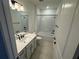 Bright bathroom with white cabinets, quartz countertops, and a shower-tub combination at 2322 Lily Bloom Rd, St Cloud, FL 34771