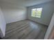 Cozy bedroom with neutral walls, wood-look floors, and a window providing natural light at 2322 Lily Bloom Rd, St Cloud, FL 34771