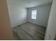 Bright bedroom featuring a window with blinds, neutral paint, and wood-look flooring throughout at 2322 Lily Bloom Rd, St Cloud, FL 34771