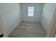 Minimalist bedroom with gray vinyl floors, a window with blinds, and a closet door at 2322 Lily Bloom Rd, St Cloud, FL 34771