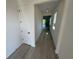 Bright hallway featuring wood-look flooring, leading to an open area with sliding glass doors at 2322 Lily Bloom Rd, St Cloud, FL 34771
