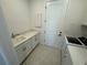 Well-lit laundry room with washer, dryer, basin, countertop, and tile flooring for easy cleaning at 2322 Lily Bloom Rd, St Cloud, FL 34771