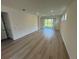 Spacious living room with wood floors, recessed lighting, and sliding glass doors to the backyard at 2322 Lily Bloom Rd, St Cloud, FL 34771