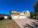 Well-maintained two-story home with a three-car garage, brick driveway, and landscaped front yard, set against a blue sky at 2387 Laurel Blossom Cir, Ocoee, FL 34761