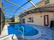 Beautiful backyard featuring a screen-enclosed pool with steps and a safety railing, surrounded by a paved patio at 2387 Laurel Blossom Cir, Ocoee, FL 34761