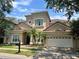 Charming two-story home boasts a two-car garage, a beautiful red tile roof, and lush landscaping with palm trees at 7014 Phillips Cove Ct # 27, Orlando, FL 32819