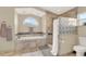 Bathroom with soaking tub, walk-in shower, and glass block feature at 1007 Tony Cir, St Cloud, FL 34772