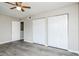 An interior shot of a bedroom with gray walls, gray wood-look flooring, and two closets at 5417 Fairwood Way # 304, Orlando, FL 32808