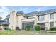 Beige two-story townhome featuring a blue roof, screened in porch, and manicured bushes at 5417 Fairwood Way # 304, Orlando, FL 32808
