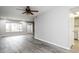 Bright living room with a ceiling fan, large window, and gray wood-look flooring at 5417 Fairwood Way # 304, Orlando, FL 32808