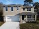 Two-story home with a two-car garage, welcoming front porch, and neutral exterior paint at 820 Debary Ave, Deltona, FL 32725