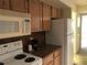 Galley kitchen with wood cabinets and granite countertops at 474 S Pin Oak Pl # 108, Longwood, FL 32779