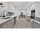 A modern kitchen featuring white cabinets, stainless appliances, and beautiful gray backsplash at 245 W George Ave, Maitland, FL 32751