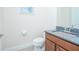 Bright half bathroom featuring granite counters, wood cabinet, and a toilet next to a window at 14046 Walcott Ave, Orlando, FL 32827