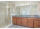 Bathroom showcasing a walk-in shower, granite double vanity, and tile floors at 14046 Walcott Ave, Orlando, FL 32827