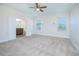 Bright primary bedroom with neutral carpet, two windows, and access to an en-suite bathroom at 14046 Walcott Ave, Orlando, FL 32827