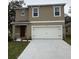 Inviting two-story home featuring a two-car garage and a neatly landscaped front yard at 3475 Sandalwood Isle Way, Ocoee, FL 34761