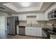 Modern kitchen with white cabinets, granite counters, and stainless steel appliances at 4533 San Sebastian Cir, Orlando, FL 32808