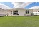 Home exterior with spacious backyard and patio with white seating at 7889 Penrose Pl, Wildwood, FL 34785