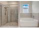 Modern bathroom with a glass-enclosed shower and a soaking tub, offering a serene and spa-like experience at 7889 Penrose Pl, Wildwood, FL 34785