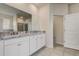Bathroom featuring double sinks with granite counters, white cabinets, and walk-in shower at 7889 Penrose Pl, Wildwood, FL 34785