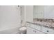 A clean, bright bathroom with granite counters and a shower-tub combo at 7889 Penrose Pl, Wildwood, FL 34785