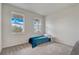 Bright bedroom featuring two windows and neutral carpet flooring at 7889 Penrose Pl, Wildwood, FL 34785