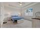 Bright bedroom features a tray ceiling, carpet flooring, a ceiling fan, and large window views at 7889 Penrose Pl, Wildwood, FL 34785